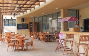 an empty restaurant with tables and chairs and a bar at Samarah E 01 full Sea View and adult pool prime location with garden , in Al Baḩḩāth