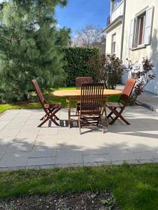 a wooden table and four chairs sitting around a table at Chez F & G terrasse privée dans jardin - parking in Sélestat