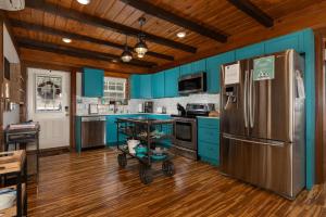 a kitchen with blue cabinets and a stainless steel refrigerator at Lakin' it Easy! - Powder Horn Mountain in Powderhorn Mountain