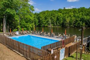 a swimming pool with chairs and a fence next to a lake at Lakin' it Easy! - Powder Horn Mountain in Powderhorn Mountain