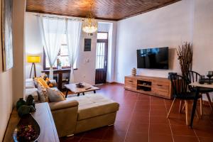a living room with a couch and a flat screen tv at White Lotus in Próti