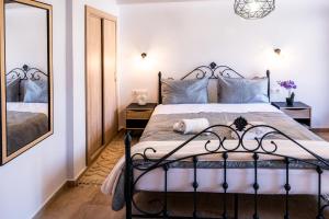 a bedroom with a large bed and a mirror at White Lotus in Próti
