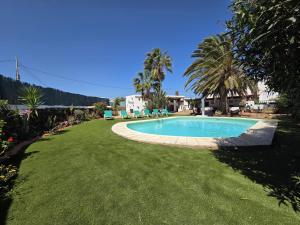 a swimming pool in a yard with green grass at Villa Majorera para 13 Huéspedes y piscina privada in Villaverde