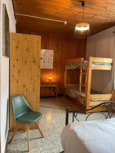 a bedroom with two bunk beds and a green chair at Le moulin de vaux in Nochizé