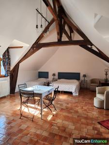 a living room with a table and two beds at Manoir de la Maison Blanche in Amboise