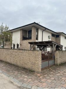 a brick fence in front of a house at Prestige Suite DS in Dunajská Streda