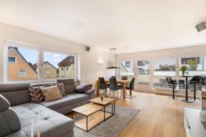 a living room with a couch and a table at Ferienwohnung Morgensonne - modern und freundlich in zentraler Lage in Langenargen
