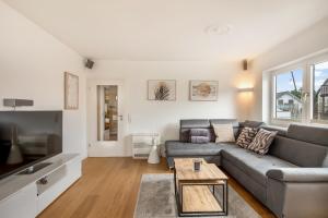 a living room with a couch and a table at Ferienwohnung Morgensonne - modern und freundlich in zentraler Lage in Langenargen