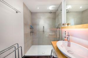 a white bathroom with a shower and a sink at Ferienwohnung Morgensonne - modern und freundlich in zentraler Lage in Langenargen +14 photos