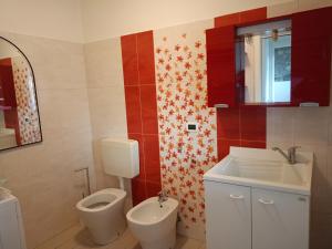 a bathroom with a toilet and a sink at Corte Don Bosco 4 in Monfalcone +5 photos