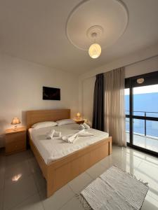 a bedroom with a bed and a large window at Heming-way Hotel in Durrës
