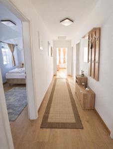 a hallway with white walls and wooden floors at Stan na dan Bumbar in Kostajnica