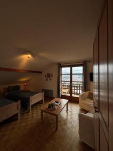 a bedroom with a bed and a couch and a table at Les Hauts du Lac in Gérardmer