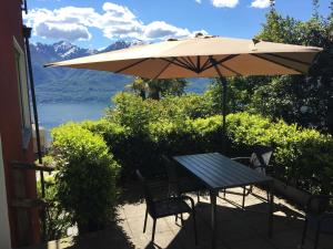 a table and chairs under an umbrella on a patio at Girasole Orselina in Orselina