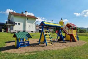 a playground with colorful play equipment in a field at Stan na dan Bumbar in Kostajnica