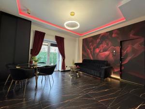 a living room with a black couch and a table at Moon Luxury Apartment - Jacuzzi & Sauna in Wałbrzych