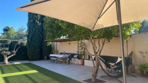 a patio with an umbrella and a table and chairs at Casa Las Fatiguitas al lado de Torrijos y muy cerca de Toledo y de Puy du Fou in Caudilla
