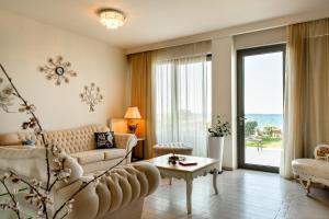 a living room with a couch and a table at Sea View Beachfront Villa Maria in Gouves