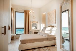 a bedroom with a bed with a view of the ocean at Sea View Beachfront Villa Maria in Gouves