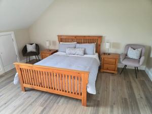 a bedroom with a large bed and two chairs at Sheehan's in Bealaclugga