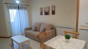 a living room with a couch and a table at Apartamento primera línea playa d samil in Vigo