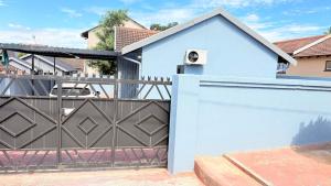 a house with a white fence and a gate at 33OnPangolin B&B in Nelspruit