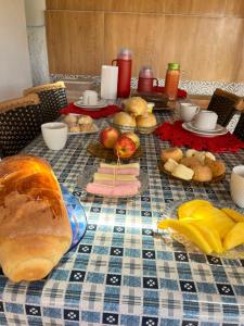 a table with a table cloth with bread and other foods at Suíte Freitas Piri in Pirenópolis