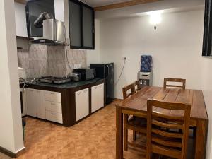 a kitchen with a wooden table and a dining room at Mughal Empire Hotel Pvt ltd in Pātan