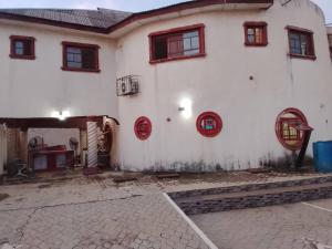 a white house with red windows and a courtyard at July 16th hotel and event centre in Alagbado +70 photos