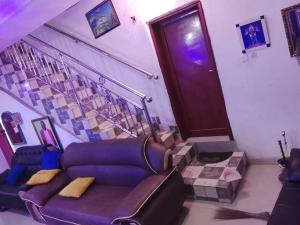 a living room with a couch and stairs with a door at July 16th hotel and event centre in Alagbado