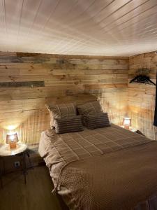 a bedroom with a wooden wall with a bed and two lamps at La Luna in Lanaken +15 photos