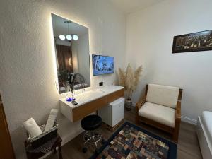 a bathroom with a sink and a chair and a mirror at Manga guesthouse in Gjirokastër +34 photos