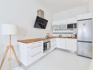 a kitchen with white cabinets and a refrigerator at Beautiful and Spacious Studio in Helsinki in Helsinki
