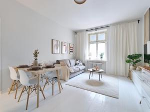 a white living room with a table and a couch at Beautiful and Spacious Studio in Helsinki in Helsinki +8 photos