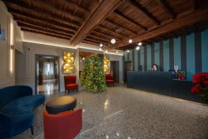 a lobby with a christmas tree in the middle at Villa Clementi Boutique Hotel in Cave