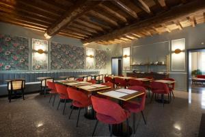 a restaurant with wooden tables and red chairs at Villa Clementi Boutique Hotel in Cave