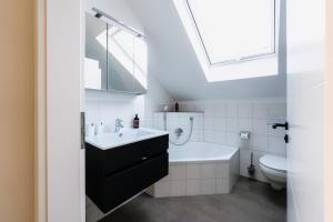 a bathroom with a sink and a tub and a toilet at Seethal in Laufen +20 photos