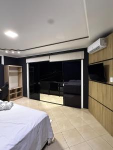a bedroom with a bed and a flat screen tv at Casa Bragança suíte in Bragança