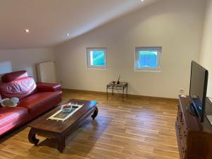 a living room with a red couch and a coffee table at Appartement in Yssingeaux