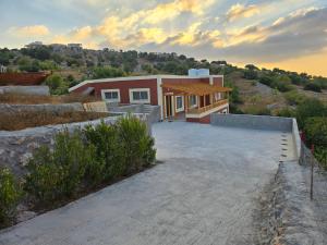 a house with a large driveway in front of it at بيت اطلالة الوادي in Ajloun