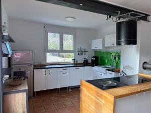 a kitchen with white cabinets and green accents at Ferienhaus Alpenblick in Steinen +12 photos