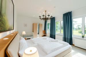 a bedroom with a large bed and a chandelier at Ferienwohnung Fehmarn in Fehmarn