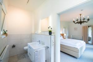 a white bathroom with a bed and a sink at Ferienwohnung Fehmarn in Fehmarn +63 photos