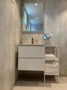 a bathroom with a white sink and a mirror at Deer Cottage in Sylte