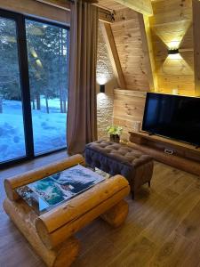 a living room with a tv and a couch and a table at Villa Aleksandra in Žabljak
