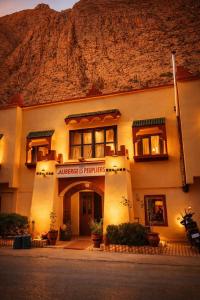 a building with a motorcycle parked in front of it at Auberge des peupliers Café Restaurant in Akhendachou nʼAït Ouffi