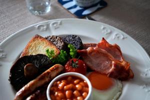 a plate of breakfast food with eggs bacon beans and toast at Kirkhill Cottage B&B in Crossmichael +27 photos