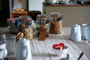 a table with jars of seeds and a bowl of fruit at Kirkhill Cottage B&B in Crossmichael