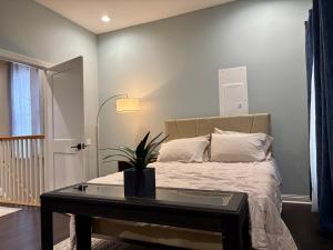 a bedroom with a bed and a table with a potted plant at Cozy Gem Mins from U of L Hospital & Downtown in Louisville