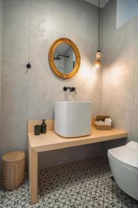 a bathroom with a white sink and a mirror at Suite Amalaya Κατώι in Kithnos